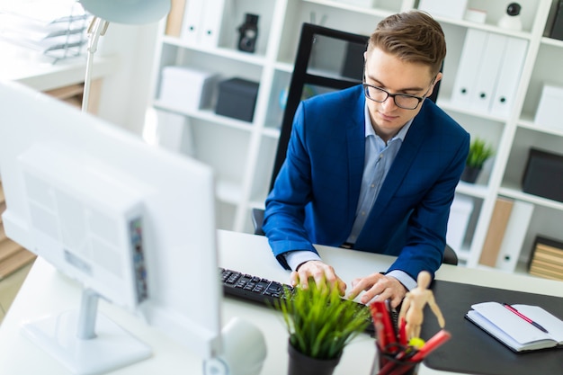 A young man is working at the computer in the office.