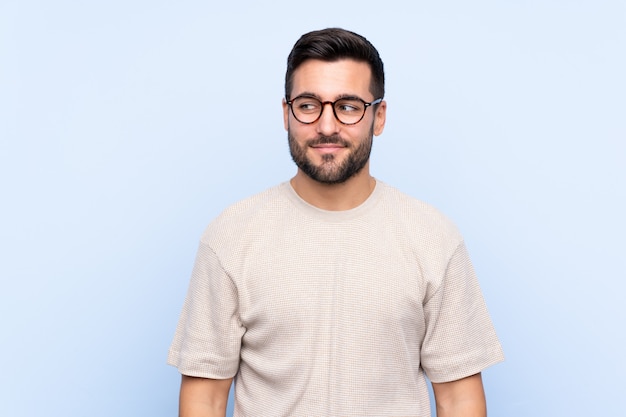 Young man over isolated blue wall