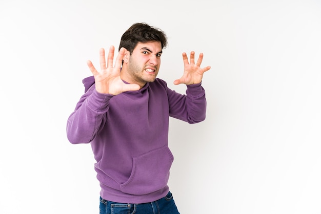 Young man isolated on white background upset screaming with tense hands.