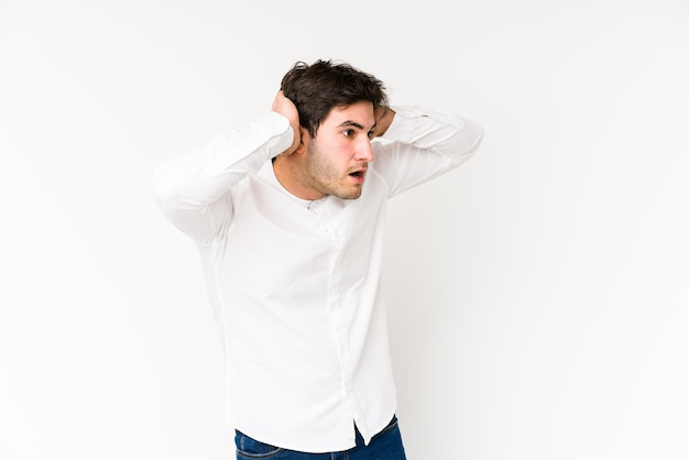 Young man isolated on white screaming, very excited, passionate, satisfied with something.