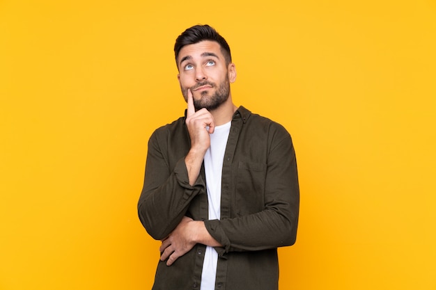 Young man over isolated yellow wall