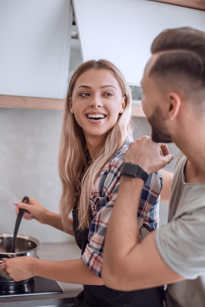 Young man joking with his wife in the kitchen