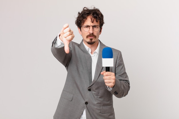 Young man journalist feeling cross,showing thumbs down