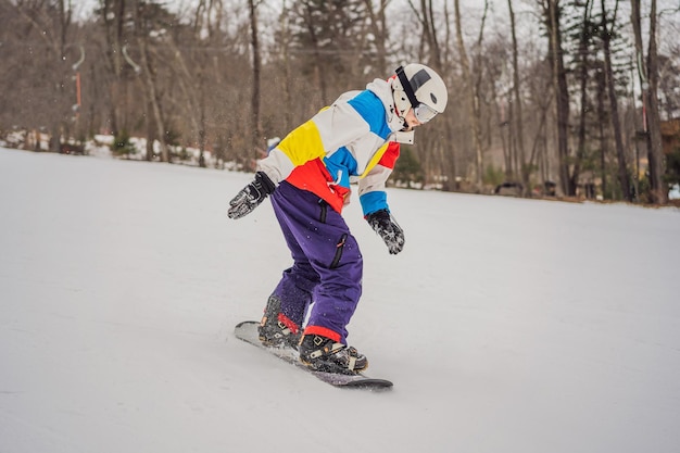 Young man jumping with a snowboard in the mountains