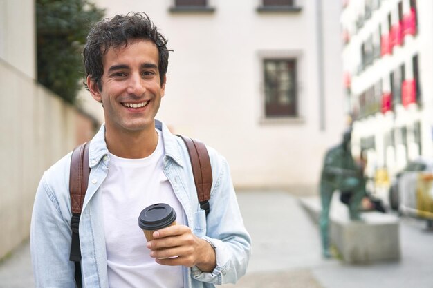 Young man kicks off his busy day with a refreshing takeout coffee on his way to work in the city