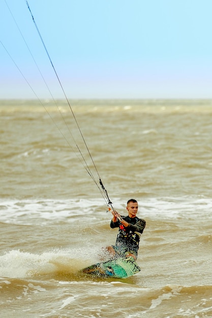 Young Man KiteBoarding on the waves Extreme Sport Kitesurfing