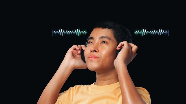 Young man listening at headphones with sound waves