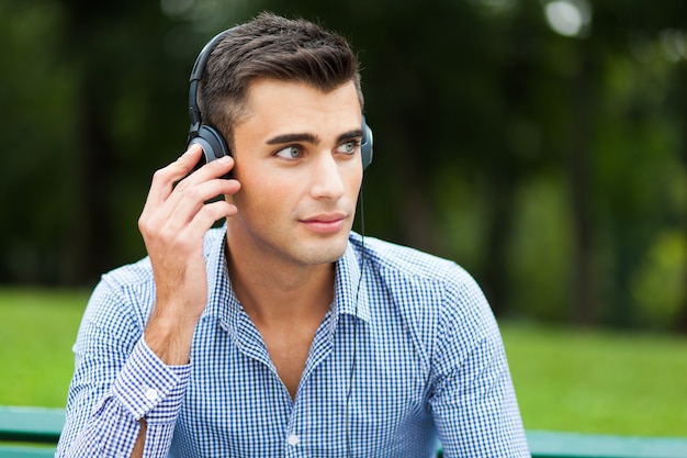 Young man listening to music in a city park