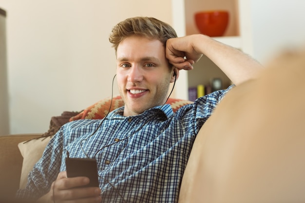 Young man listening to music on his couch 