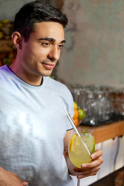 Young Man look into his fresh cocktail