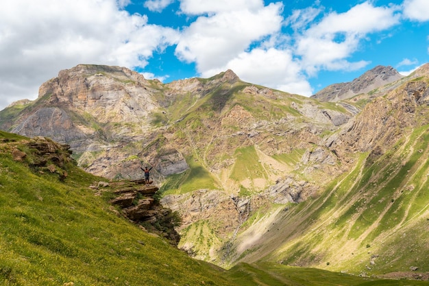 A young man looking at the landscape in the rincon del verde and the Salto de Tendenera Waterfall in the Ripera Valley Pyrenees