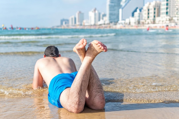 Young man lying on the beach