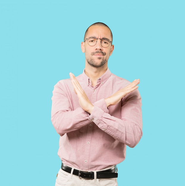 Young man making a gesture of not crossing with the arms