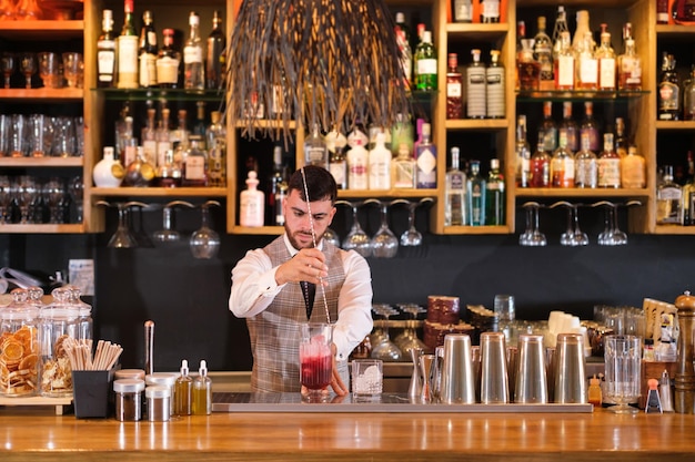 Young man making very special cocktails and creating experiences for consumption Concept bartender mixologist drinks