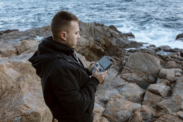 Young man operating a drone over the sea High quality photo