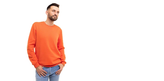 A young man in an orange jumper looks to the side on a white background