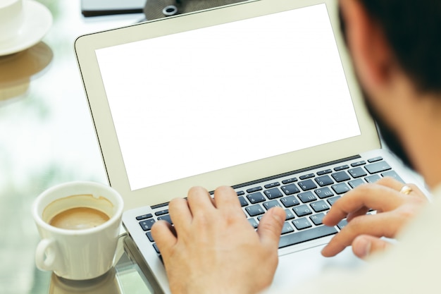 Young man performs work on a laptop