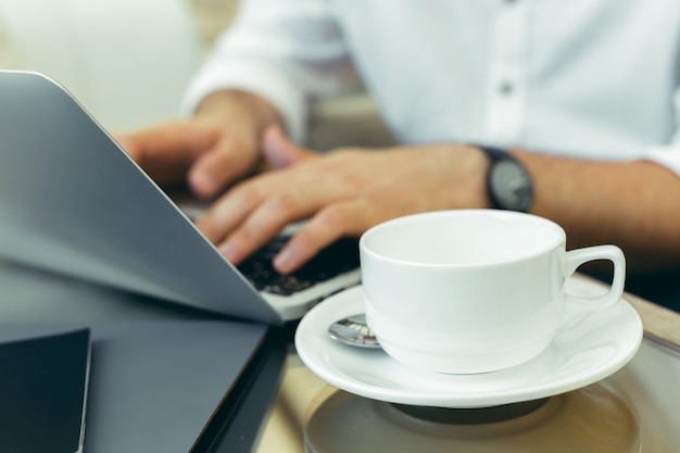 Young man performs work on a laptop