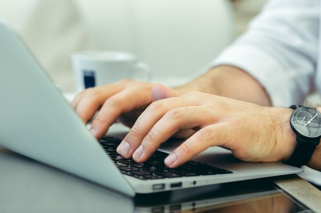 Young man performs work on a laptop