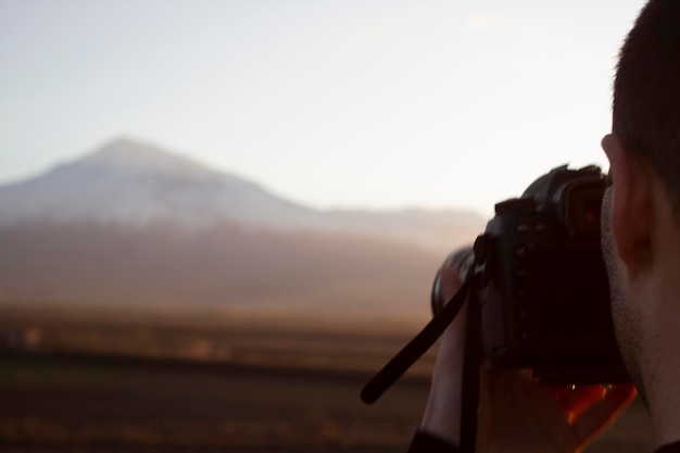 Young man photographing a mountain