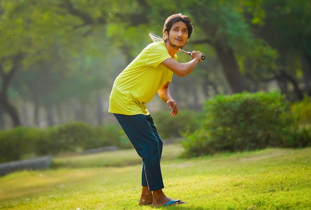 Young man playing badminton outdoors