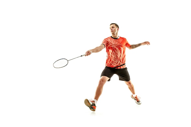 Young man playing badminton on white studio. Fit male athlete isolated on white. badminton player in action, motion, movement