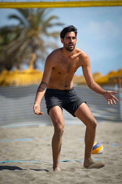 young man playing beach volleyball on the beach on a sunny day