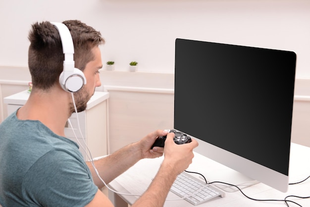 Young man playing computer games at home