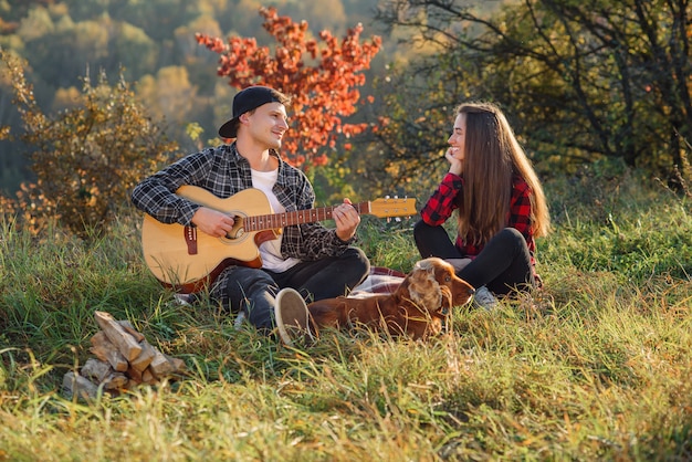 Young man playing on the guitar for his lovely girlfriend