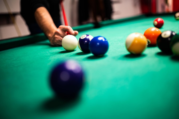 Young man playing snooker aiming for a good shot