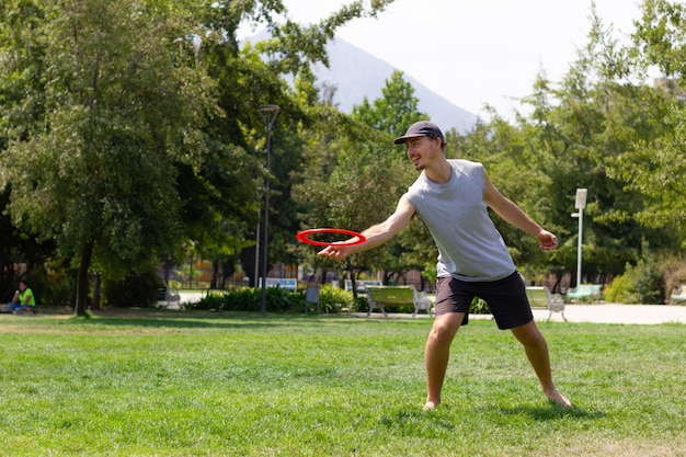 Young man playing with frisbee on sunny day at the park Sports activity recreation concepts