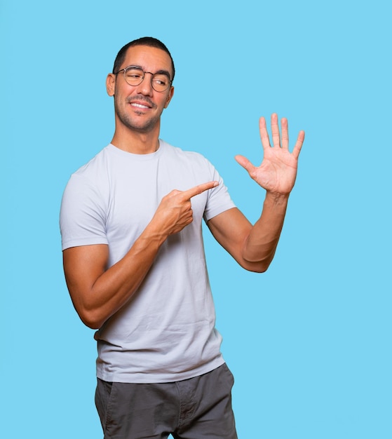 Young man pointing to his wrist