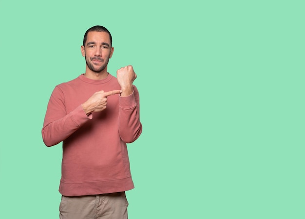 Young man pointing to his wrist