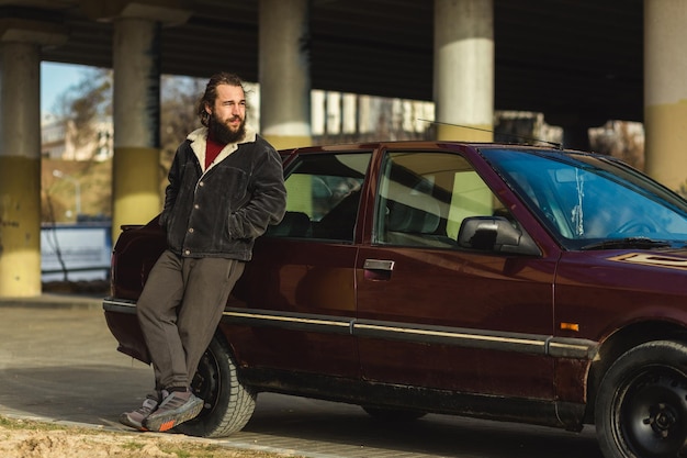 Young man poses with his car