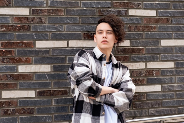 Photo young man posing against a brick wall