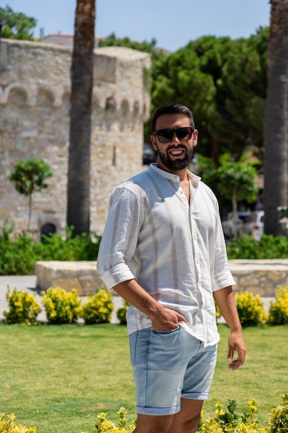 Young man posing in front of the castle and gardens of the city of Cesme Turkey