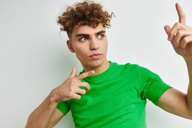 Young man posing on a white background in a green tshirt