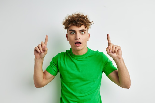 Young man posing on a white background in a green tshirt