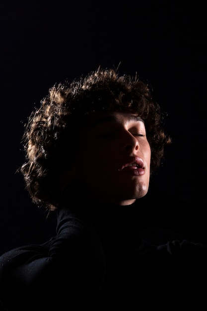 Young man posing with dark background low angle