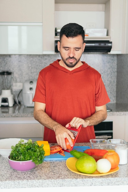 Young man preparing fresh and tasty organic vegetables