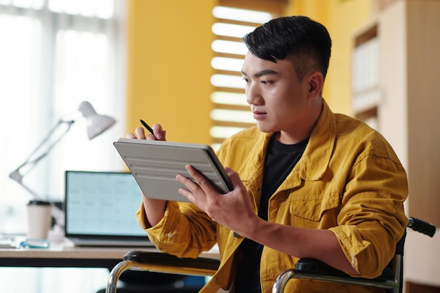 Young Man Reading Document on Tablet