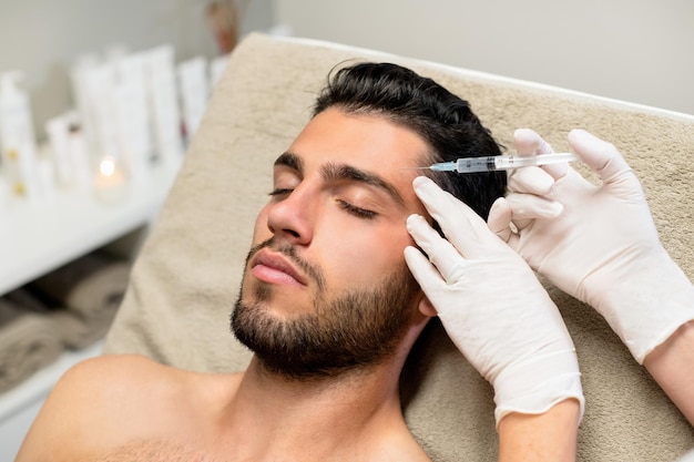 Young man receiving botox injection