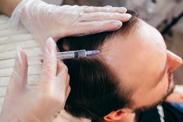 Young man receiving injection, close up