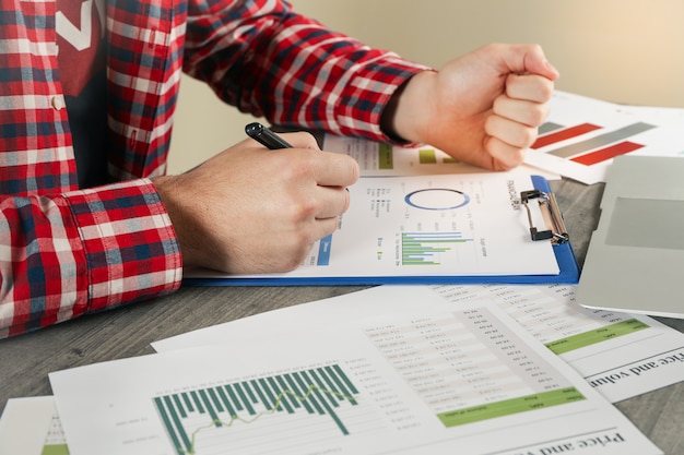 Young man in red shirt is engaged in financial planning