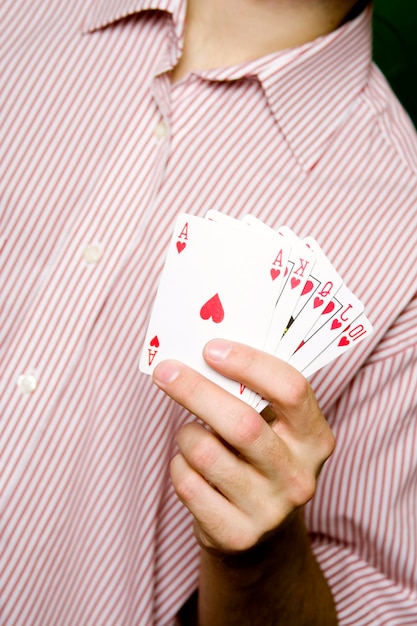 A young man in a red striped shirt holding Royal flush