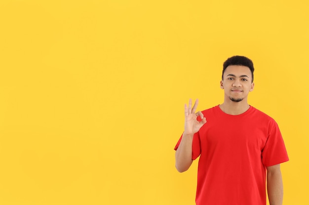 Young man in red t-shirt on yellow background