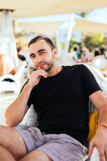 Young man relax at outdoor cafe.