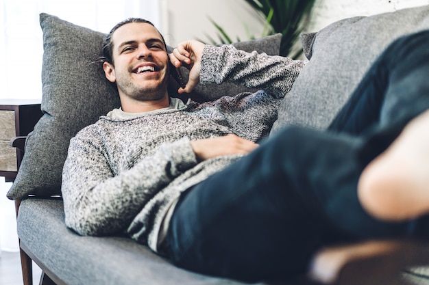 Young man relaxing and using smartphone.man checking social apps and working.Communication and technology concept