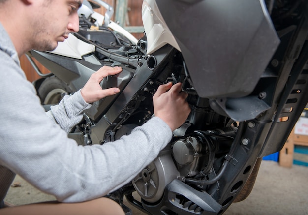 Young man repairing the motorcycle