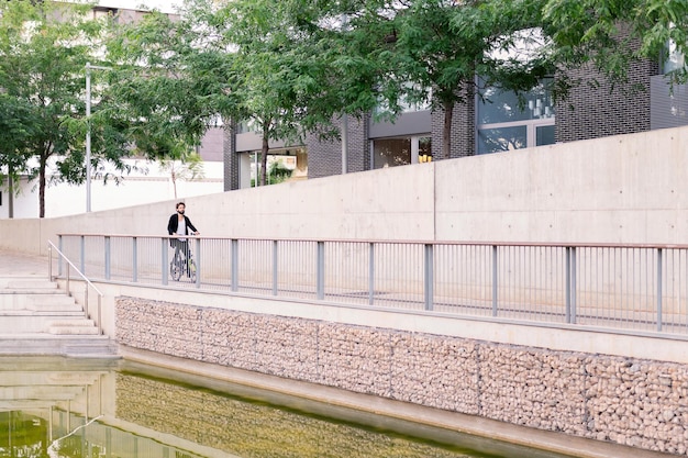 Young man riding his bike by the city